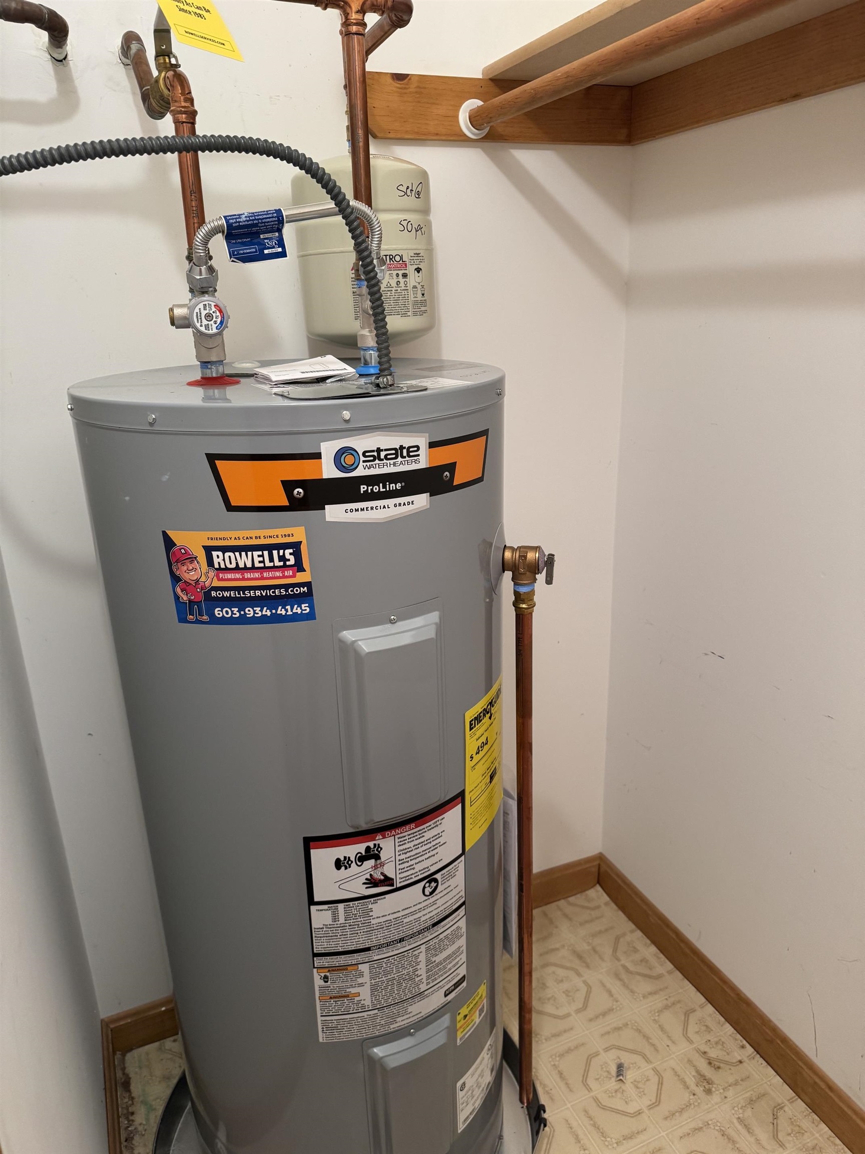 Gray State ProLine water heater with copper pipes in a small utility closet.