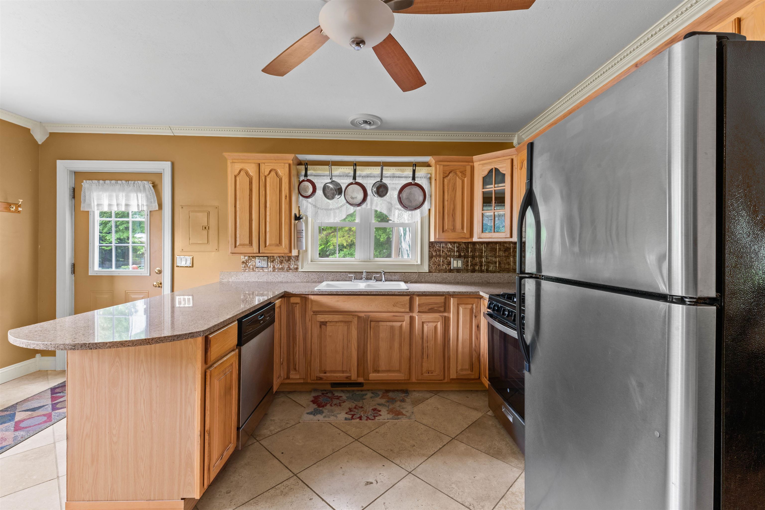 Kitchen with wood cabinets, a granite peninsula, and stainless steel appliances.