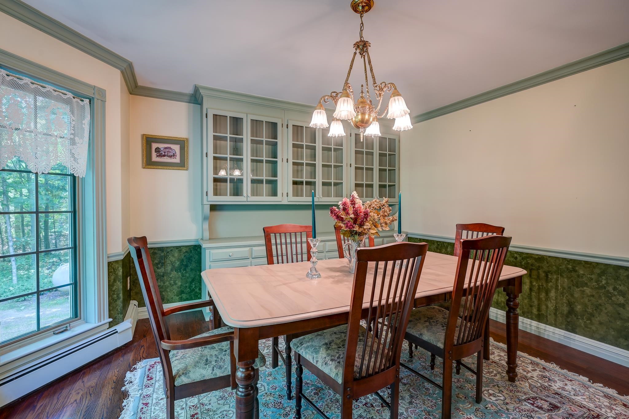 Dining room with a wooden table, glass-front cabinets, and a chandelier.