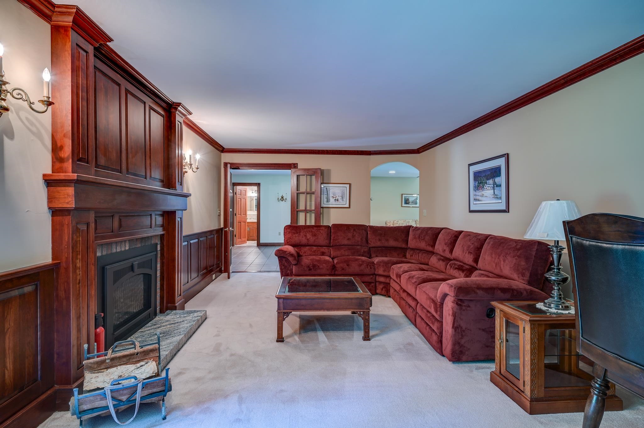 Living room with a red sectional sofa and dark wood fireplace surround.