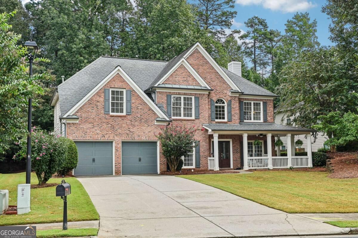 Two-story brick house with a double garage, covered porch, and wide driveway.
