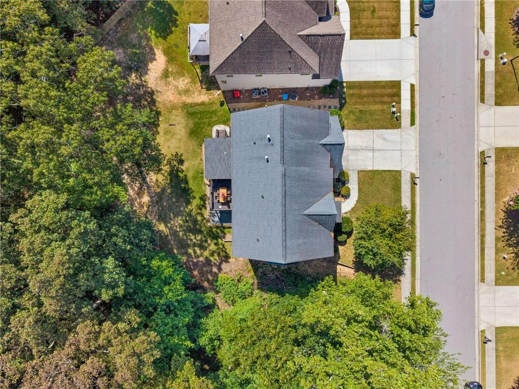 Aerial view of 1239 Side Step Trace, with its gray roof beside a tree-lined backyard and street.