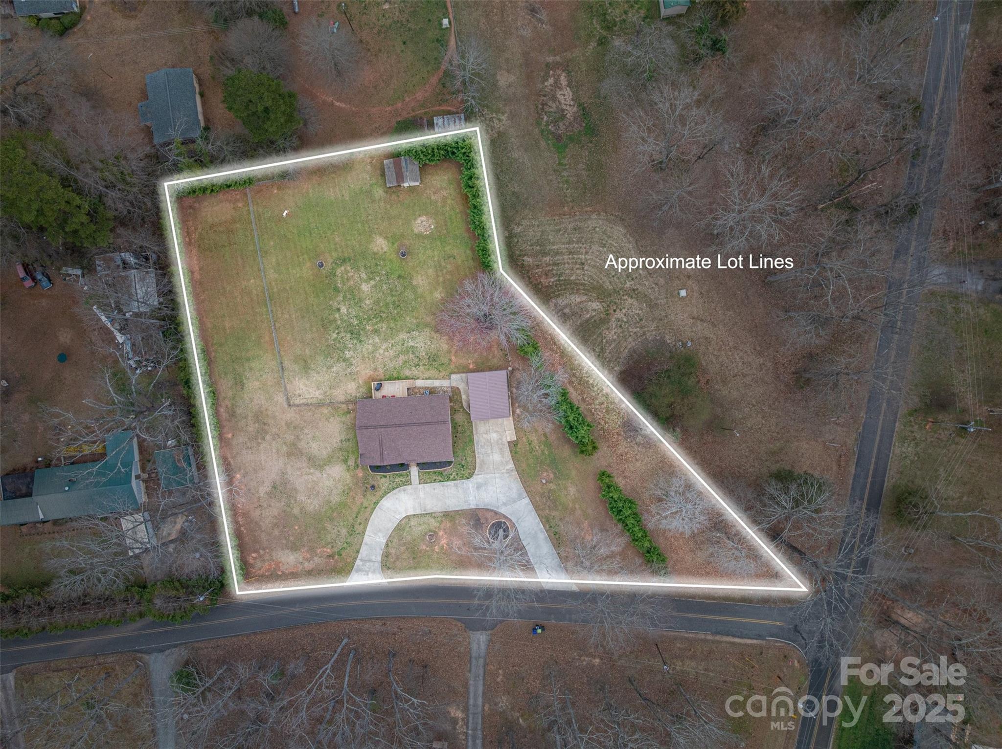 Aerial view of the house and yard outlined to show approximate lot lines, with a curved driveway and road frontage.