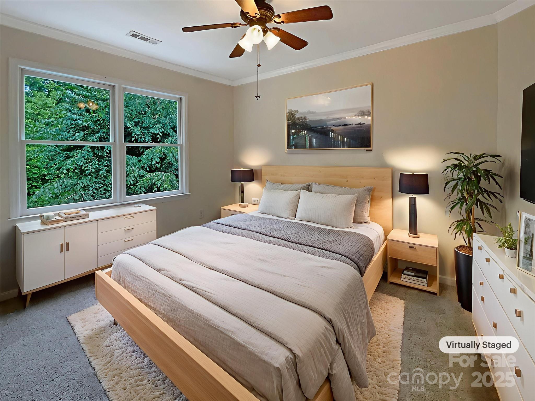 Virtually staged bedroom with a light wood bed, gray bedding, and large windows overlooking greenery.