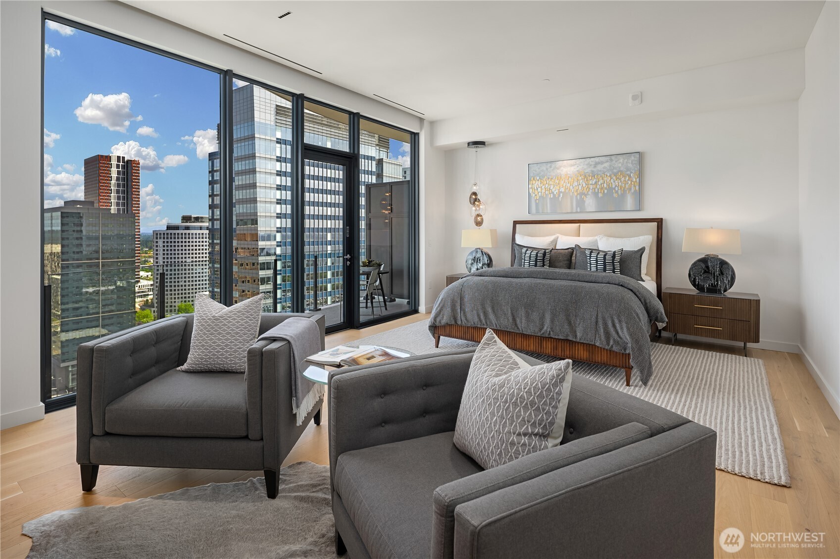 Staged high-rise bedroom with floor-to-ceiling windows overlooking downtown Bellevue.