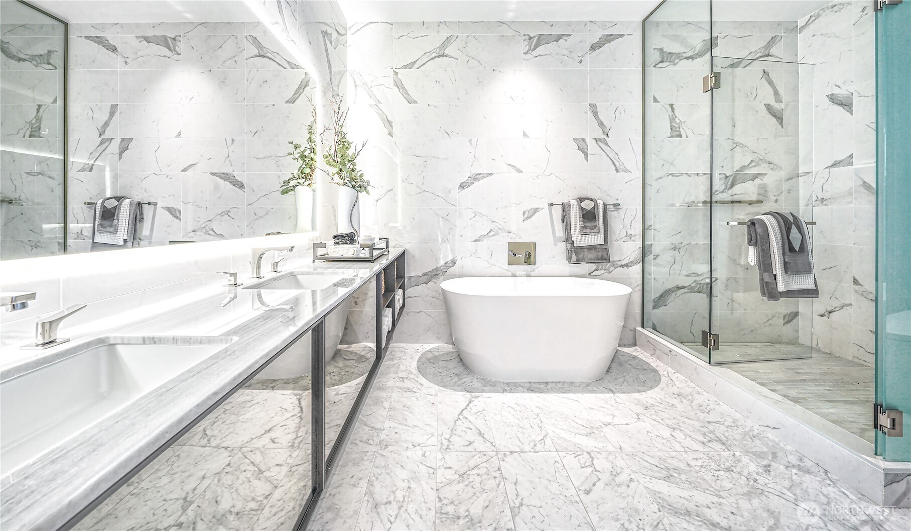 Marble bathroom with a freestanding tub, glass shower, and double vanity.