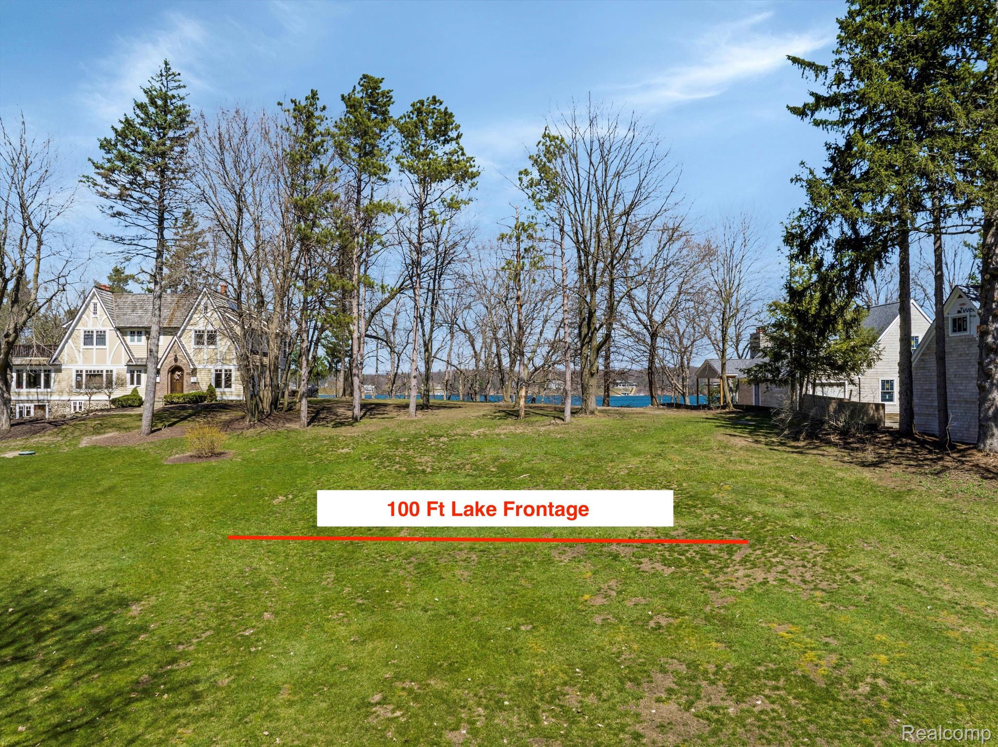 Grassy lakefront property with 100 feet of lake frontage marked between neighboring homes.
