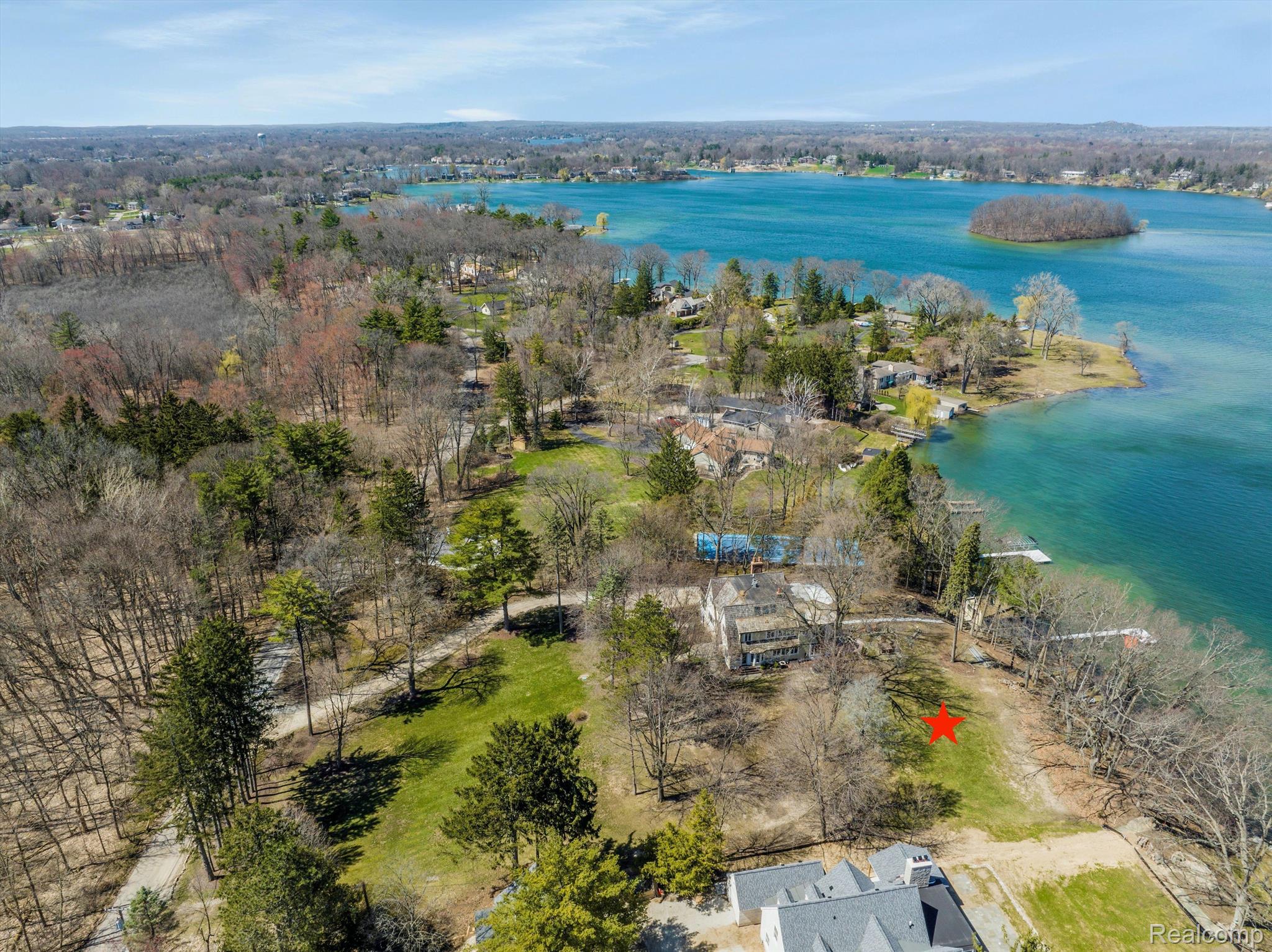 Lakeside property marked with a red star, surrounded by trees beside Lake Angelus.