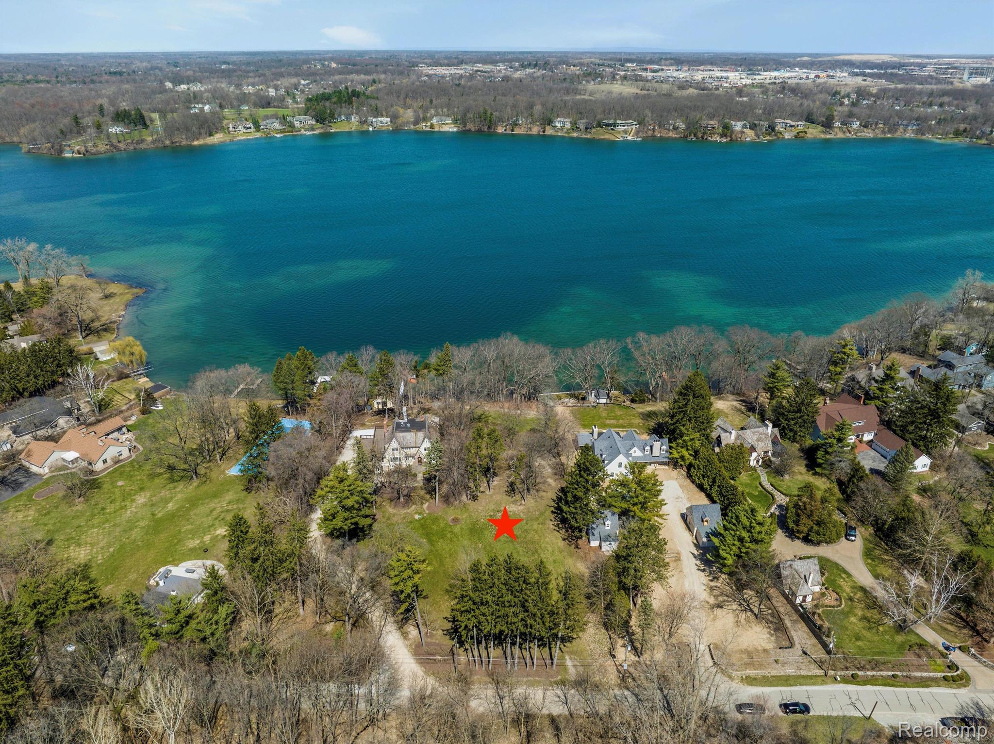 Aerial view of a marked Lake Angelus lot, with the lake and neighboring homes in view.