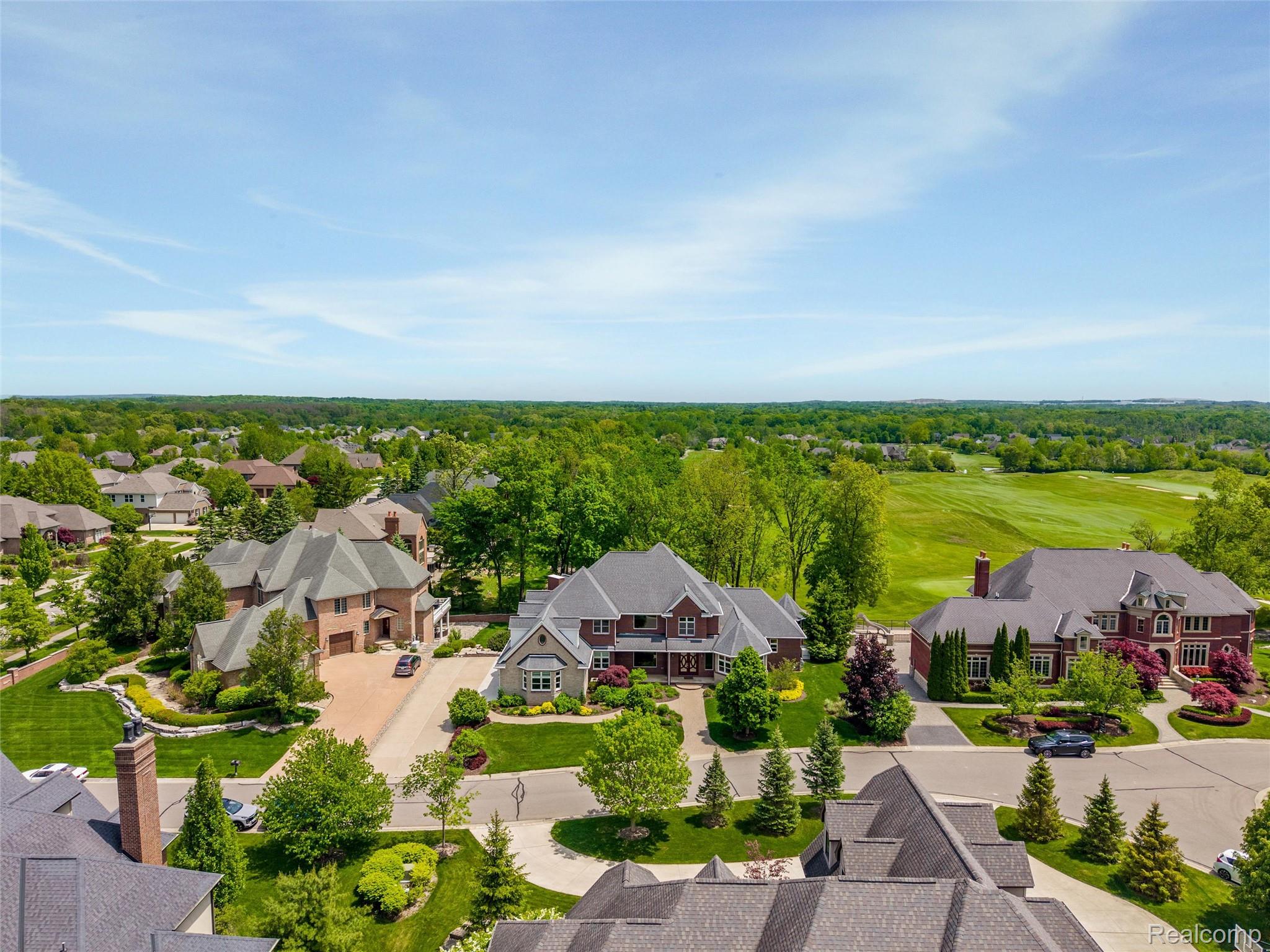Aerial view of 7432 Foxburg Court beside a golf course in a wooded neighborhood.