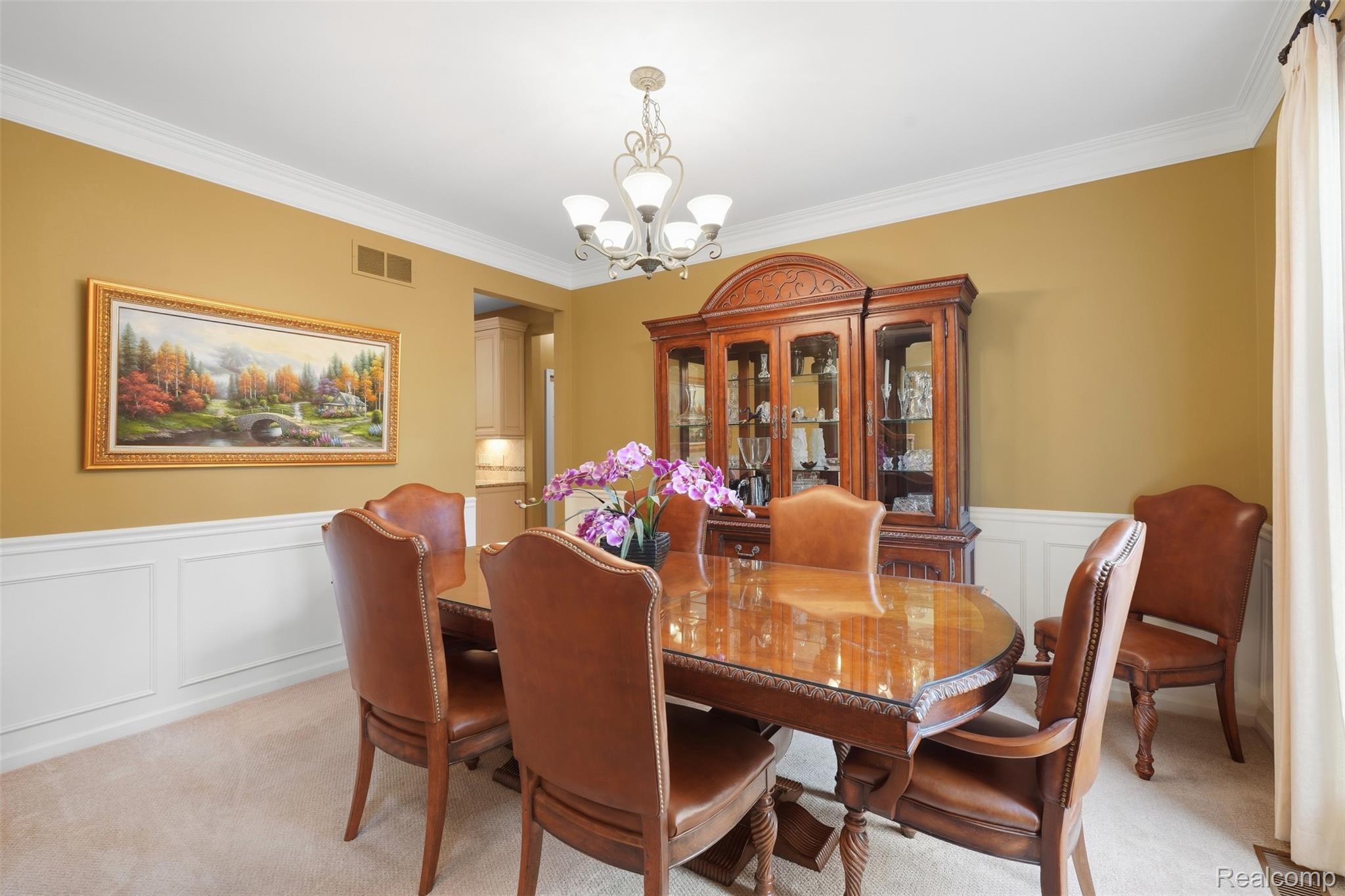 Dining room with a polished wooden table, leather chairs, and an ornate china cabinet.