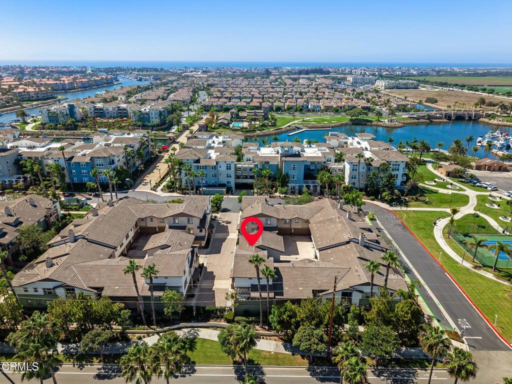 Aerial view of Seabridge homes beside waterways, with a red marker pinpointing a property.