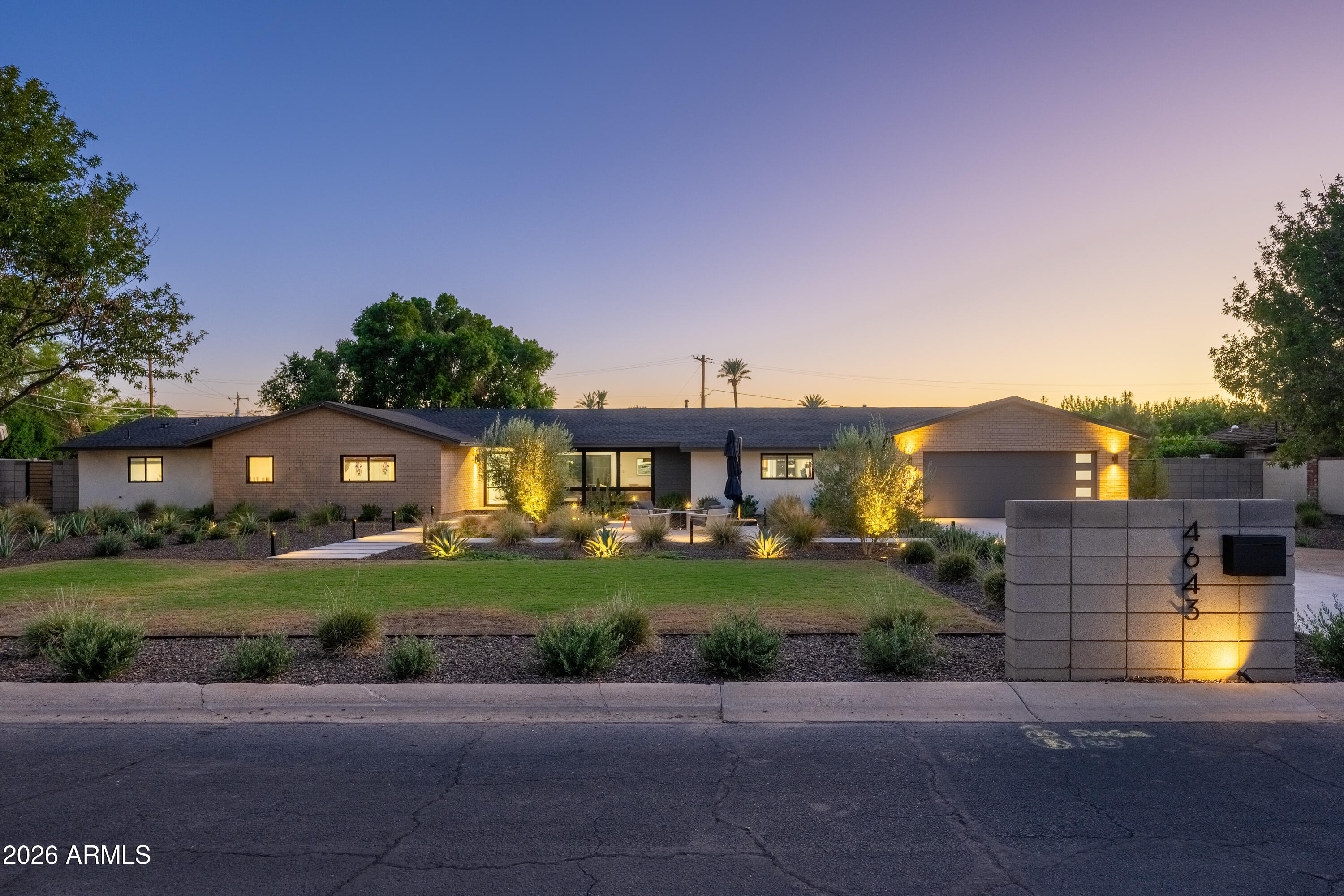 Single-story Arcadia home at dusk with illuminated landscaping and address pillar marked 4643.