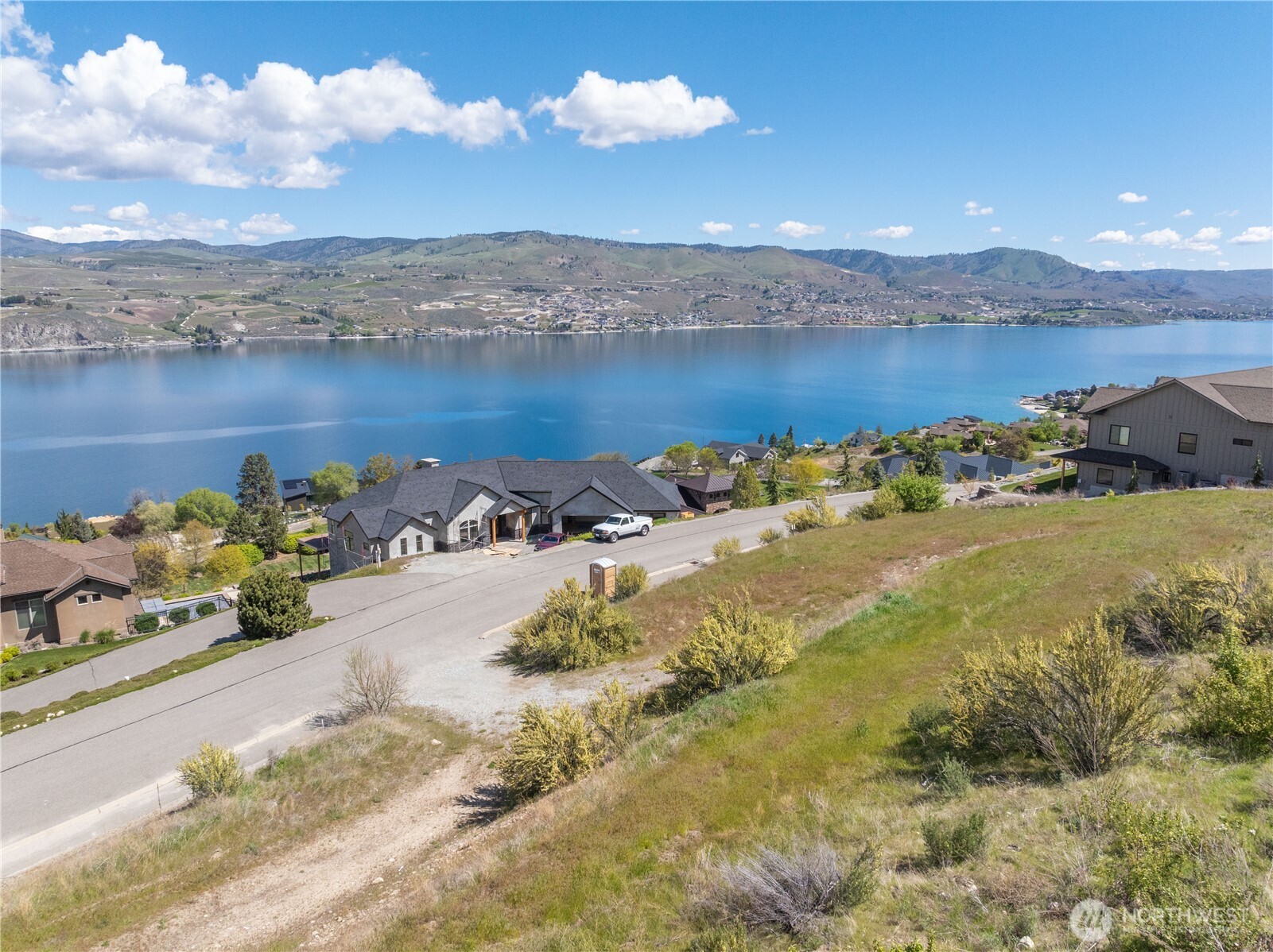 Hillside homes above Lake Chelan, with broad lake and mountain views.