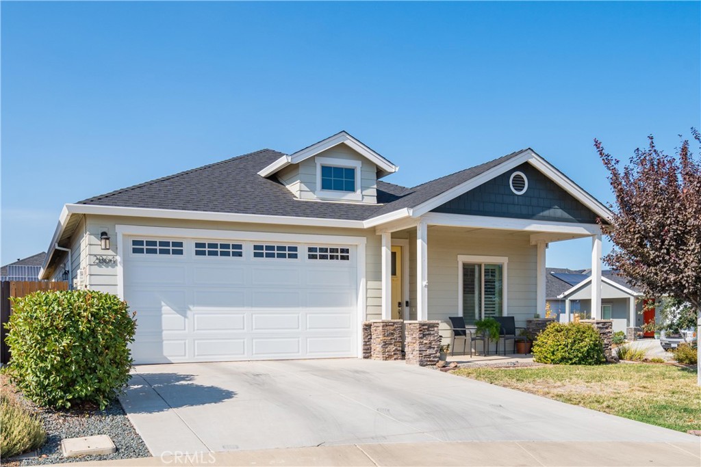 Single-story house with a two-car garage and covered, furnished front porch.