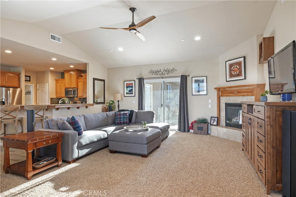 Living room with gray sectional, fireplace, and sliding glass doors to the patio.