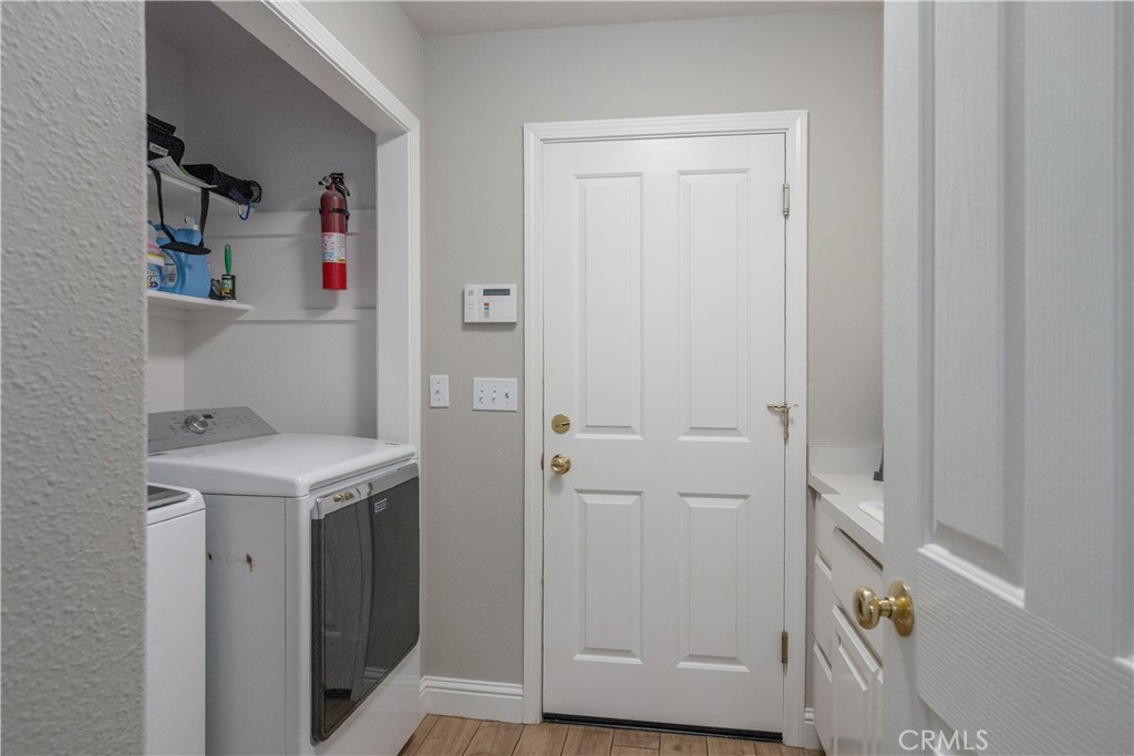 Laundry room with washer and dryer beside a white paneled door.