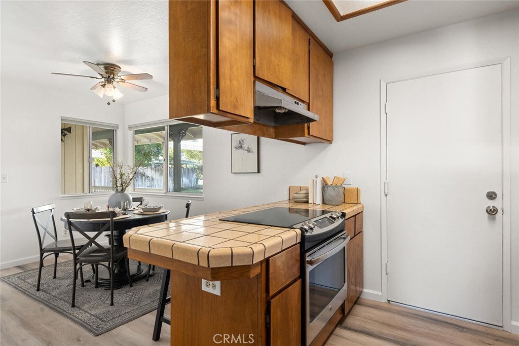 Kitchen with a tiled island, warm wood cabinets, and an adjacent dining nook.