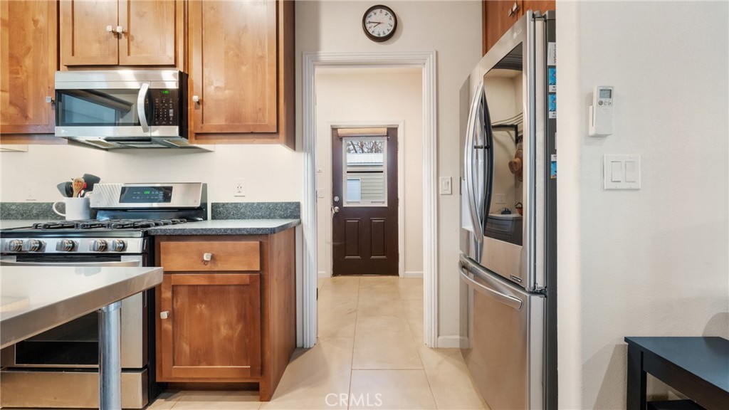 Kitchen with wood cabinets, granite counters, and stainless steel appliances.