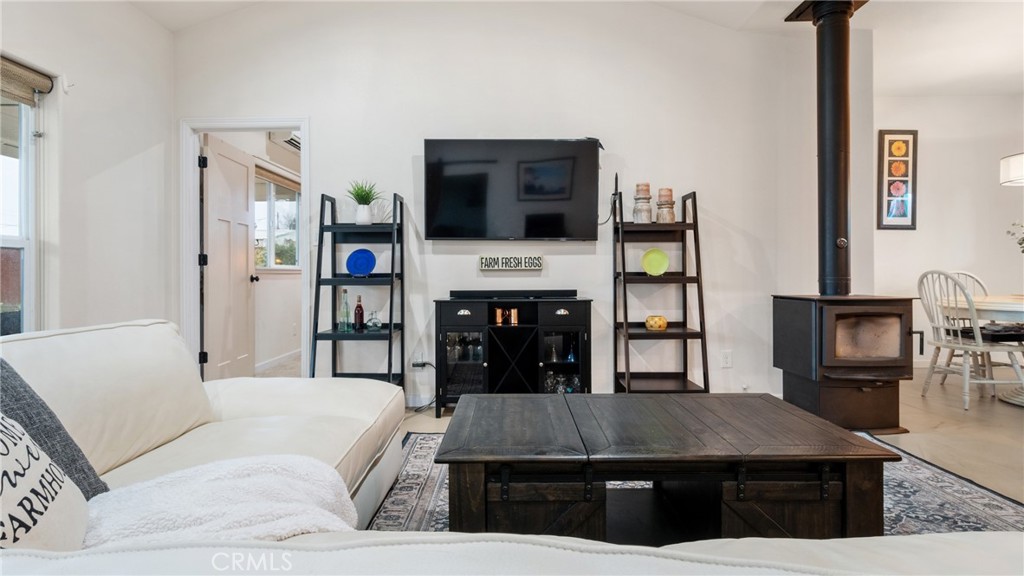Living room with a white sectional, large coffee table, and freestanding wood stove.