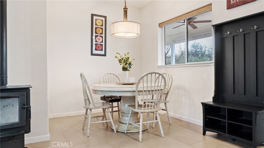 Furnished dining room with a round white table, spindle-back chairs, and black built-in bench.