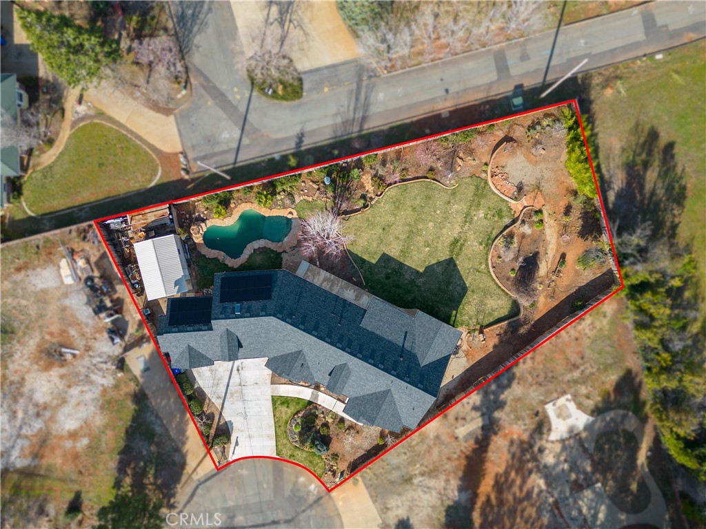 Aerial view of a home with a swimming pool and red-outlined property boundary.