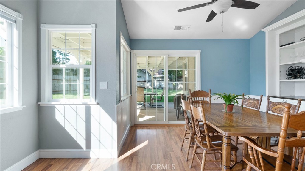 Dining room with a long wooden table, blue accent wall, and sliding doors to a covered patio.