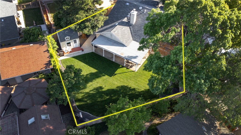 Aerial view of a home and spacious tree-lined lawn, outlined in yellow.