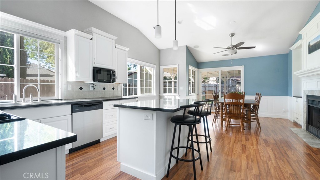 Open kitchen and dining area with a large island, black countertops, and blue dining-room walls.