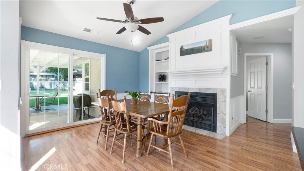 Dining room with a wooden table, tiled fireplace, and sliding glass doors to the backyard.