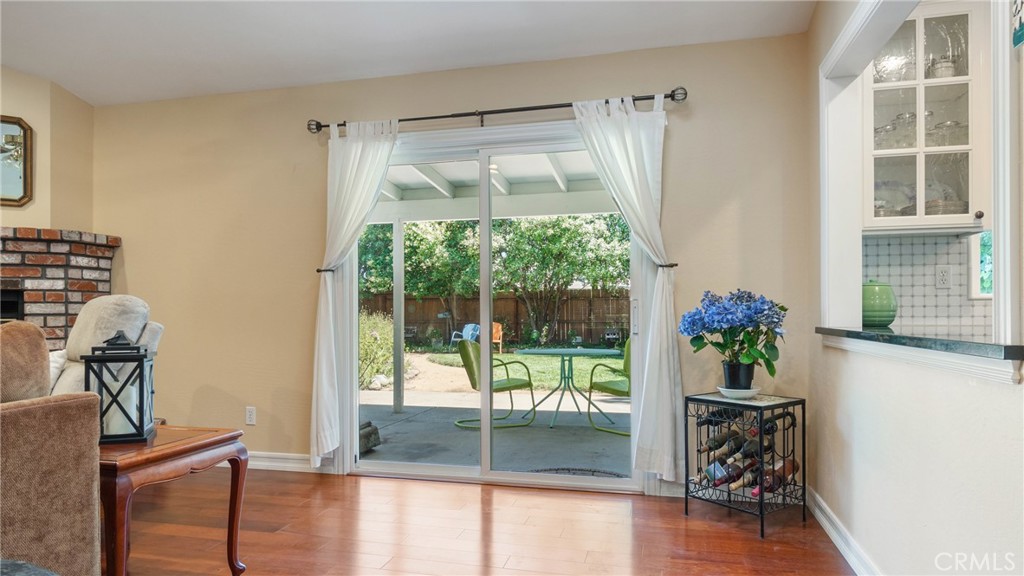 Living room with sliding glass doors opening to a covered patio and leafy backyard.