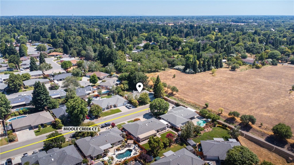 Aerial view of the neighborhood, with a pin marking the home beside a large open field.
