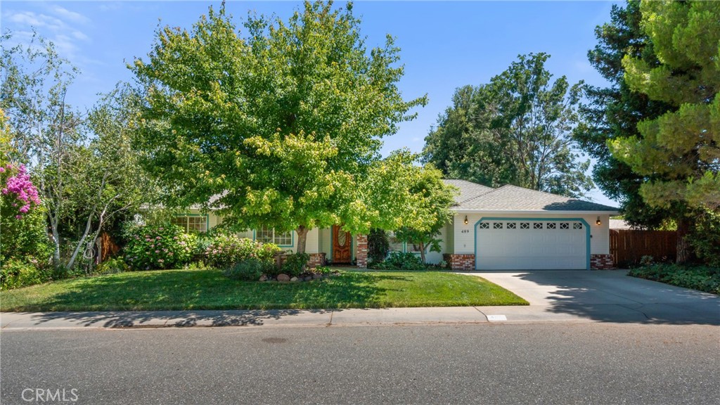 House at 489 Middle Creek Court with a two-car garage, mature trees, and a shaded front lawn.