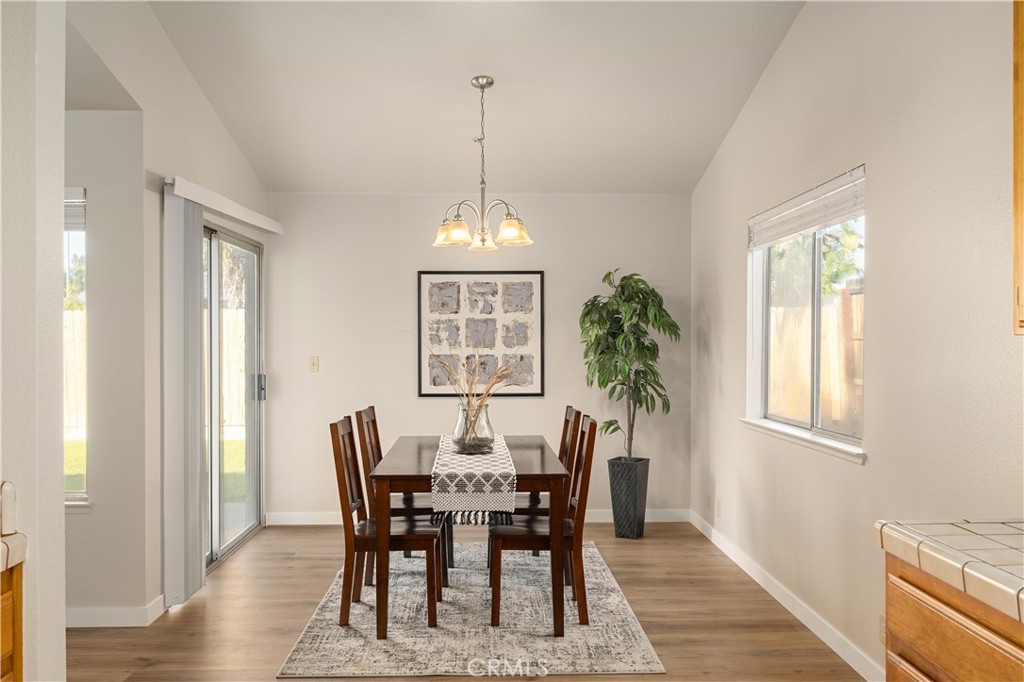 Dining room with a dark wood table, chandelier, sliding glass door, and potted plant.