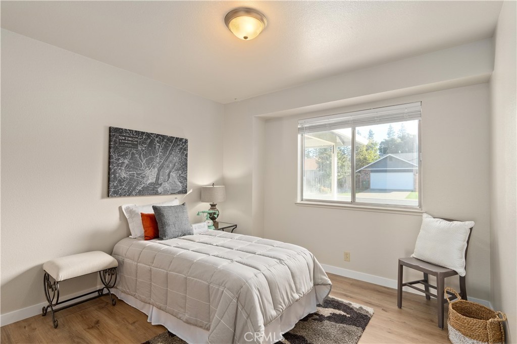 Staged bedroom with a light-quilted bed, New York City map print, and large window.