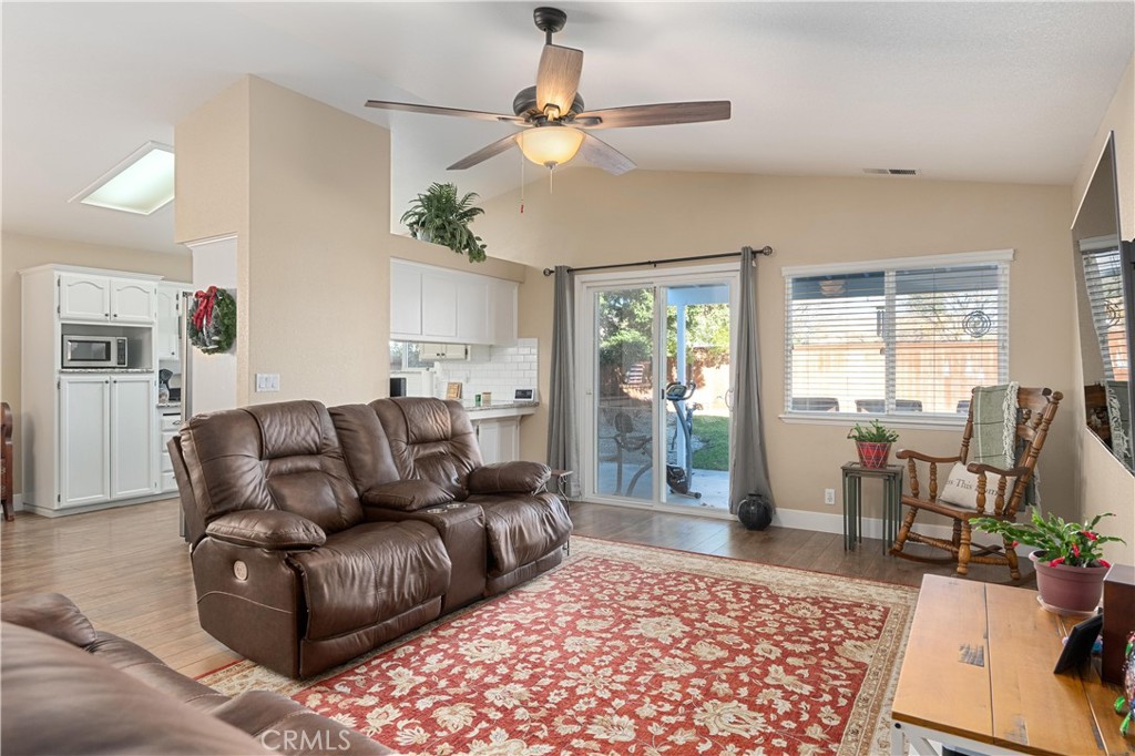 Living room with brown leather recliners, a red floral rug, and sliding glass doors to the backyard.