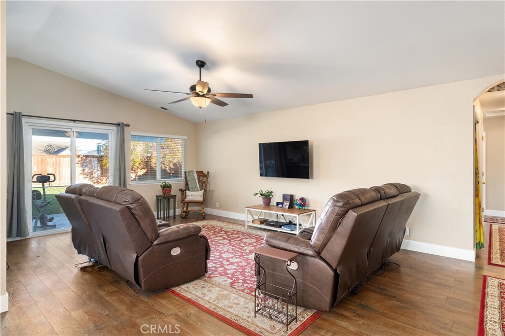 Living room with brown leather recliners, a red patterned rug, and sliding glass doors to the backyard.