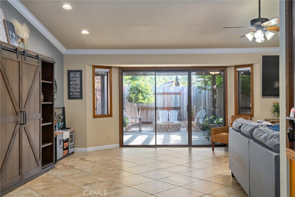 Living room with a gray sectional and sliding doors opening to a fenced patio.