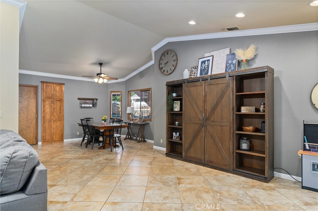 Living and dining area with tan tile floors and a large rustic wood cabinet.