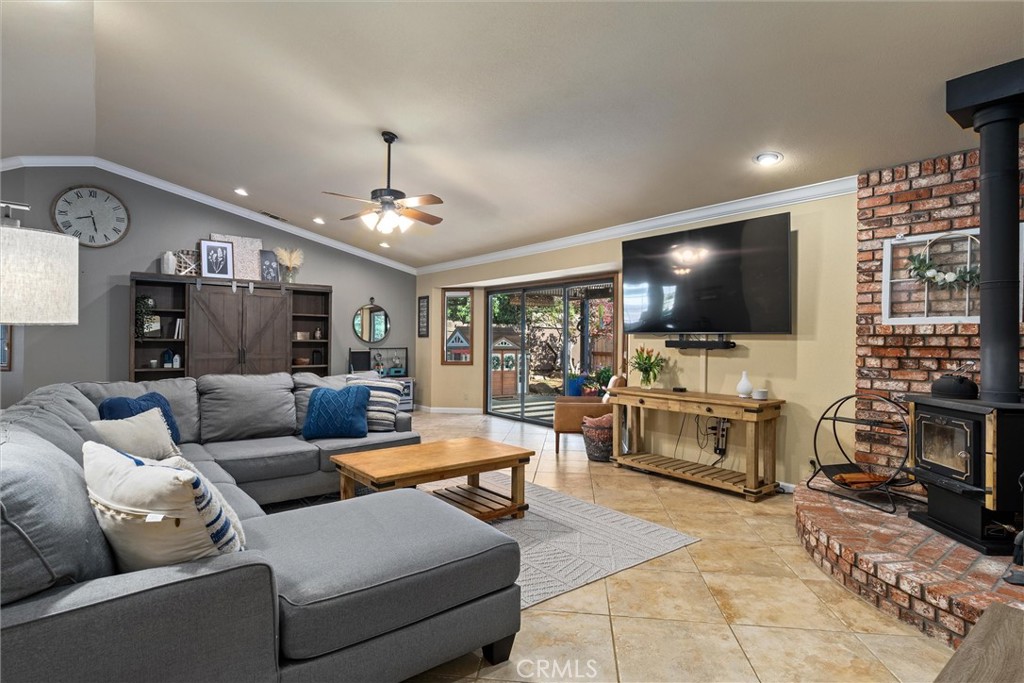 Living room with a gray sectional, sliding glass doors, and a brick fireplace with wood-burning stove.