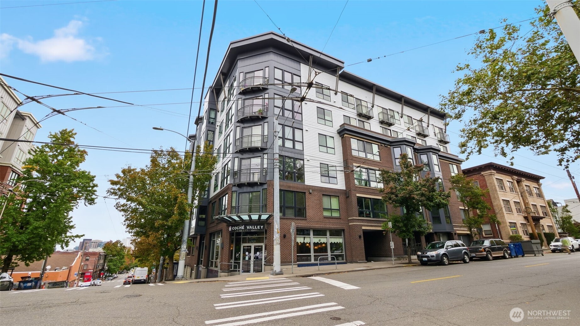 Seattle condominium building with balconies and a street-level café on a corner.