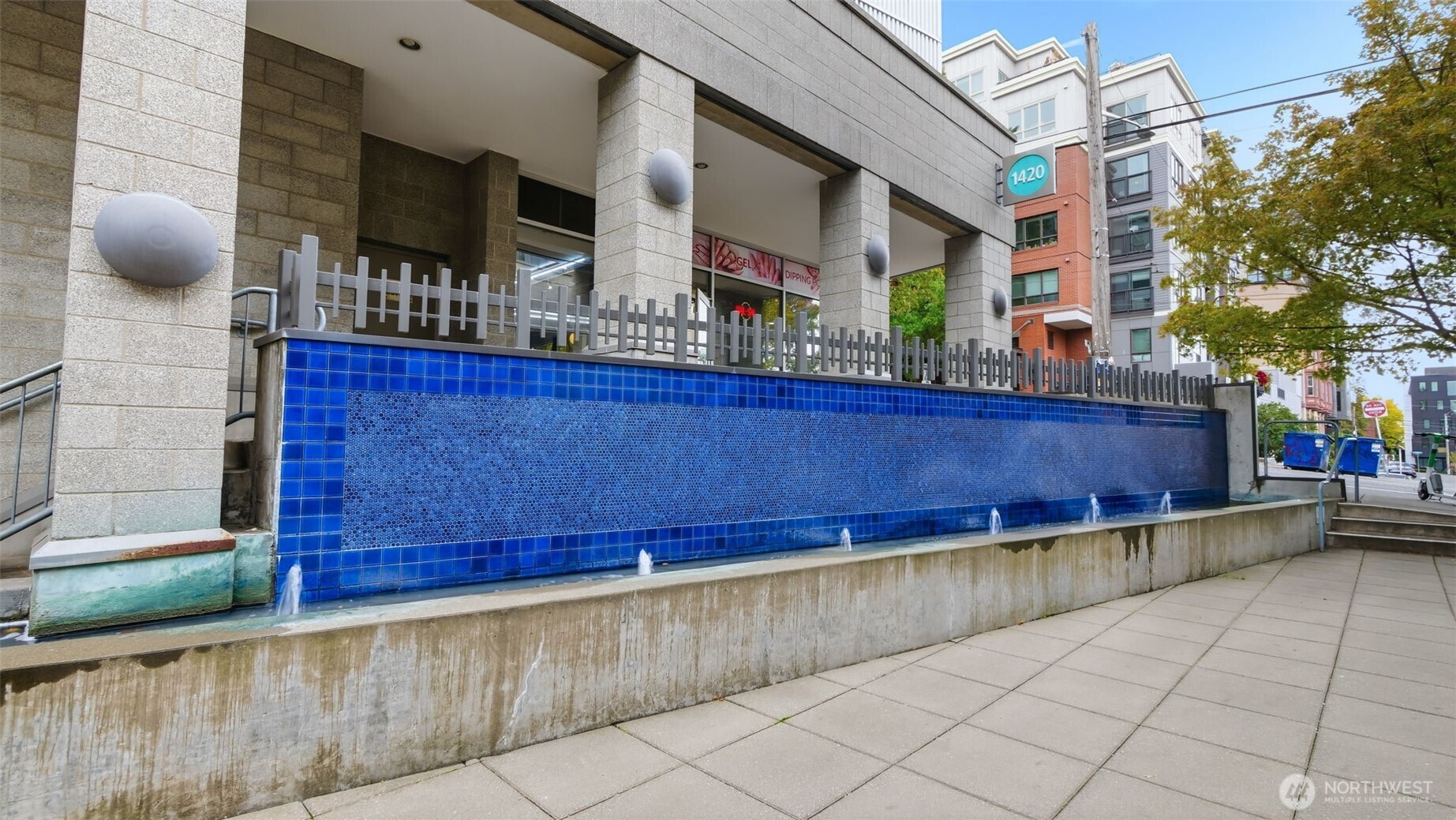 Condominium entrance with a long blue-tiled fountain and a 1420 address sign.