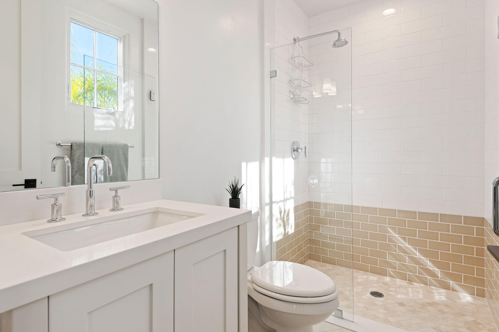 Bathroom with a white double-sink vanity, large mirror, and glass-enclosed tiled shower.