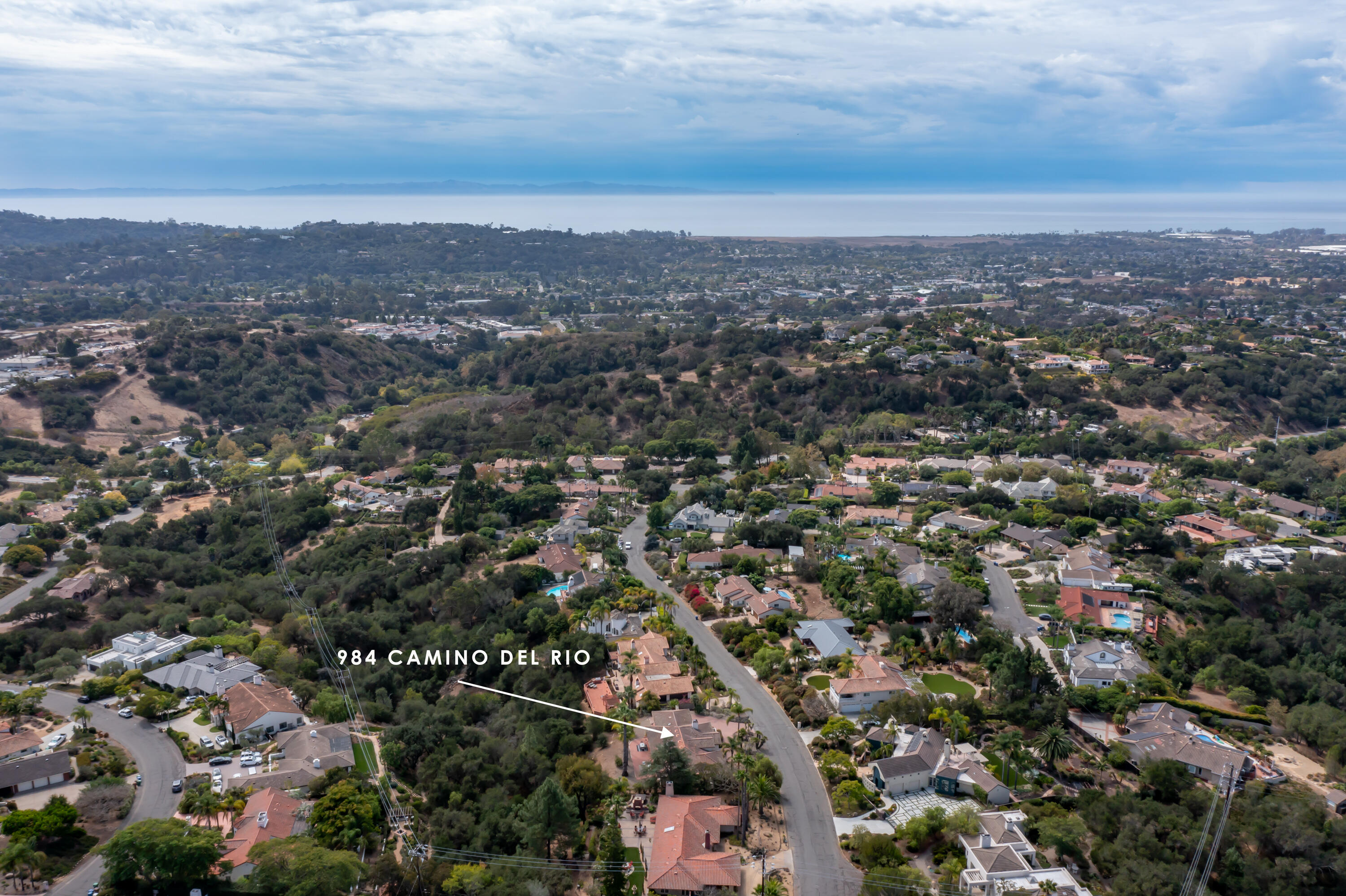 Aerial view of 984 Camino Del Rio, marked by an arrow, with the coastal neighborhood and ocean beyond.