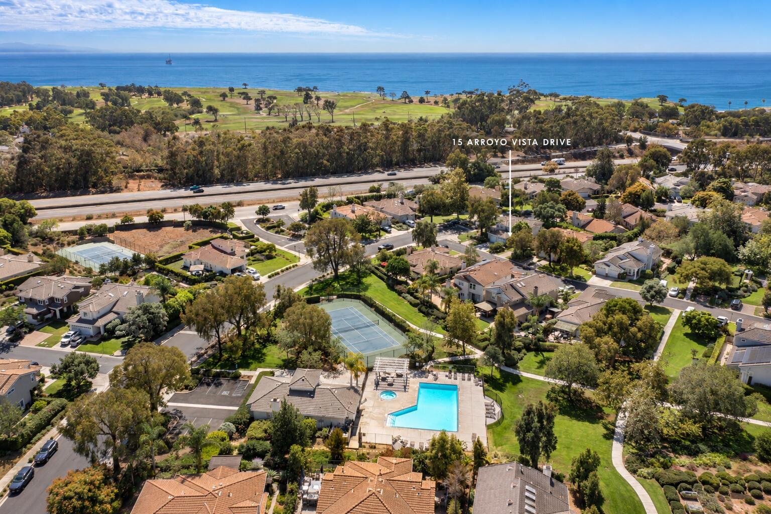 Aerial view of 15 Arroyo Vista Drive, with the Pacific Ocean and golf course in the distance.