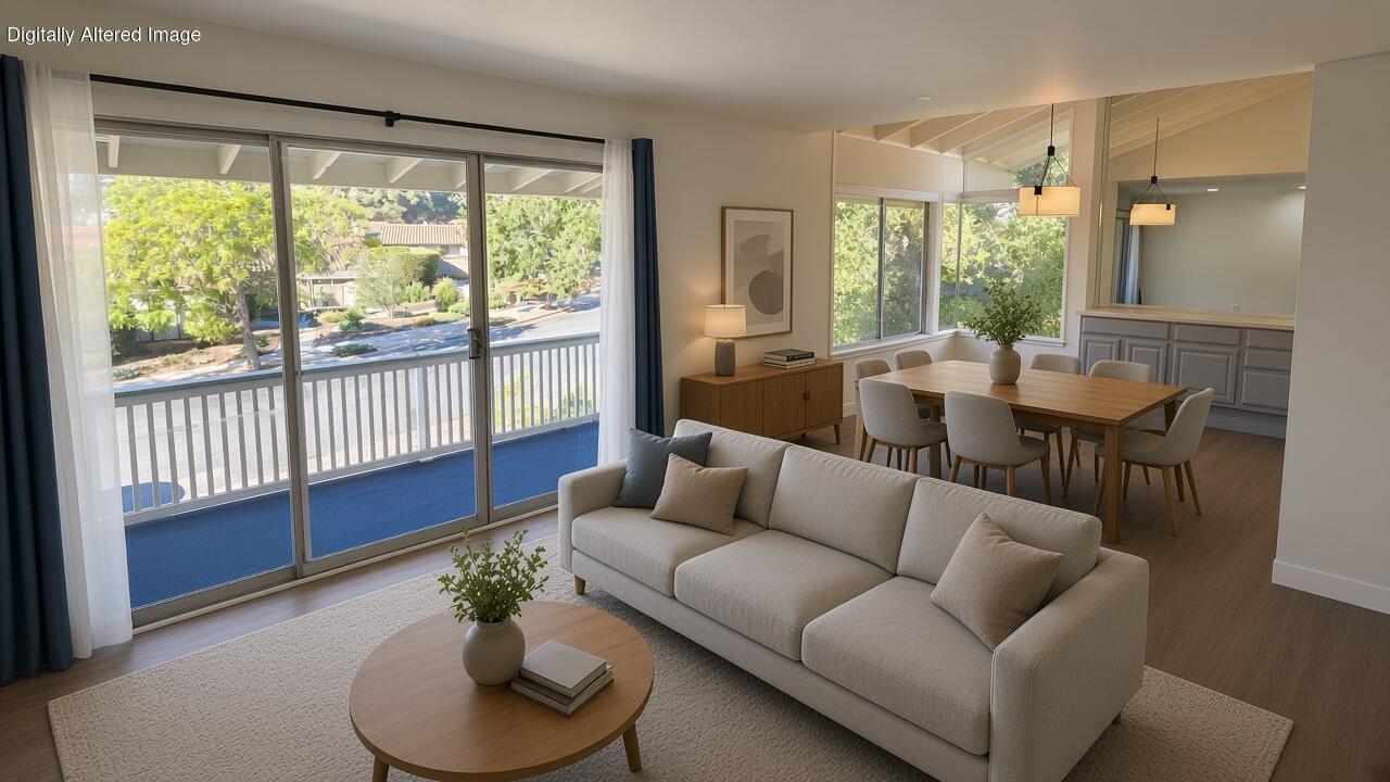 Staged living room with an open dining area and sliding doors to a balcony.