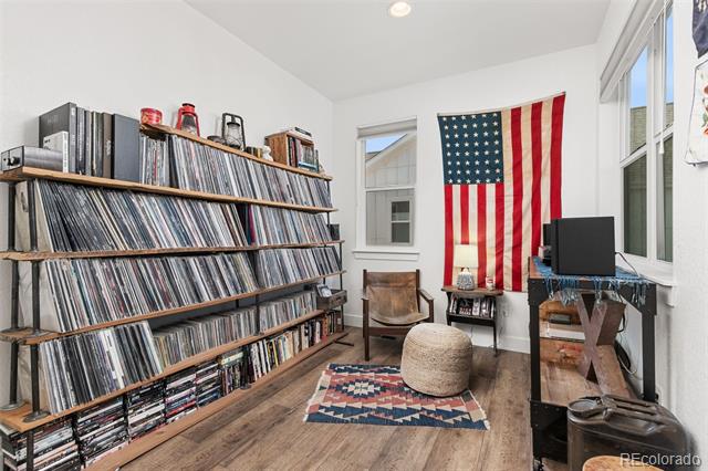 Record-filled room with tall windows, a desk, and an American flag.