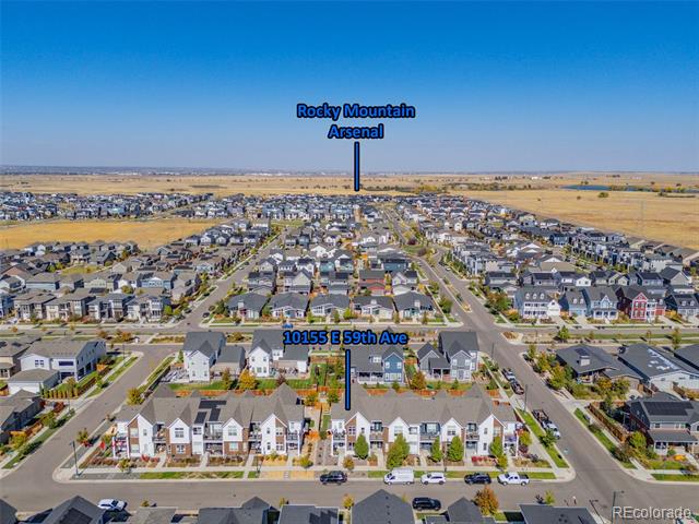 Aerial neighborhood view with 10155 E 59th Avenue outlined among rows of homes.