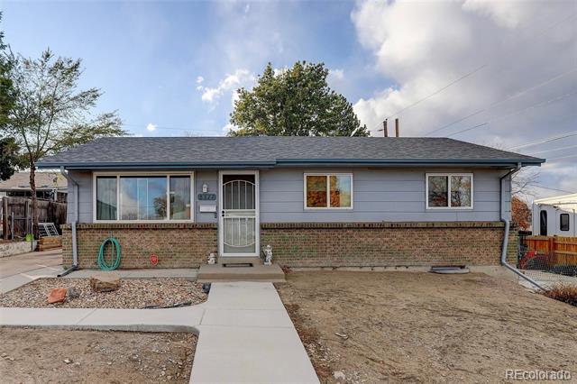 Single-story gray ranch home with brick facade, centered entry, and a concrete walkway across the front yard.