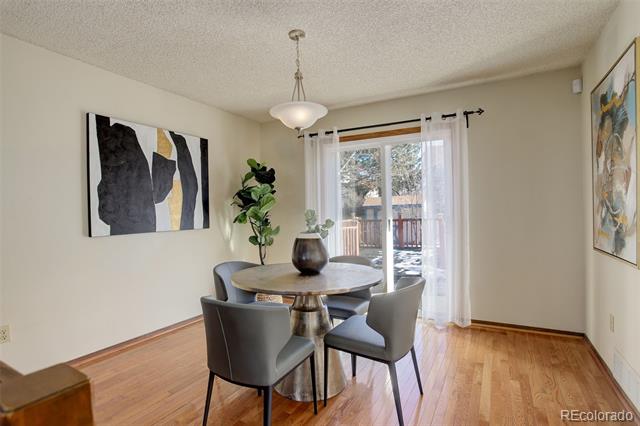 Dining room with a round table and gray chairs beside sliding glass doors to a deck.